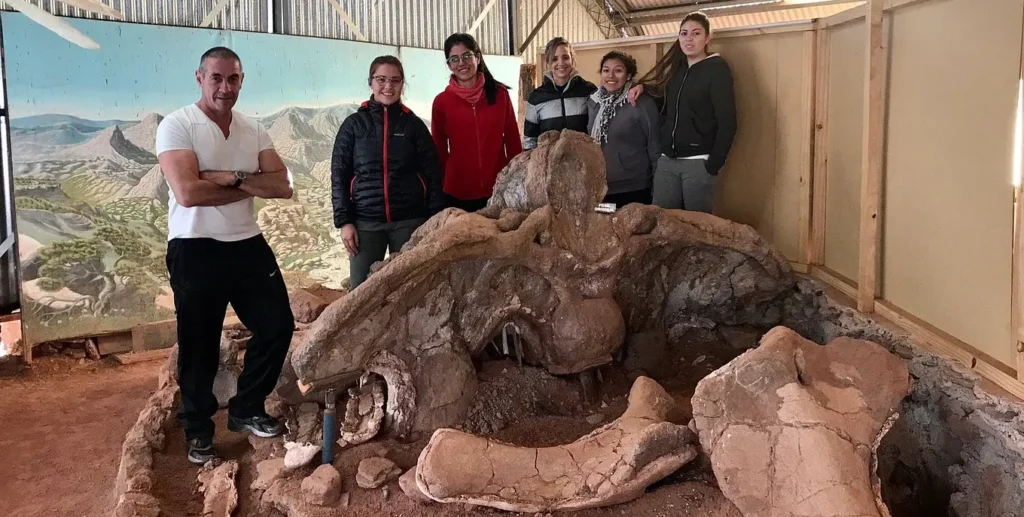 El fundador, Jorge Calvo, con estudiantes junto con la caldera de Futalongkasaurus